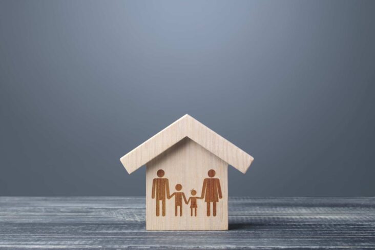 Casa estilizada de madeira com familia desenhada pata ilustrar preço das casas