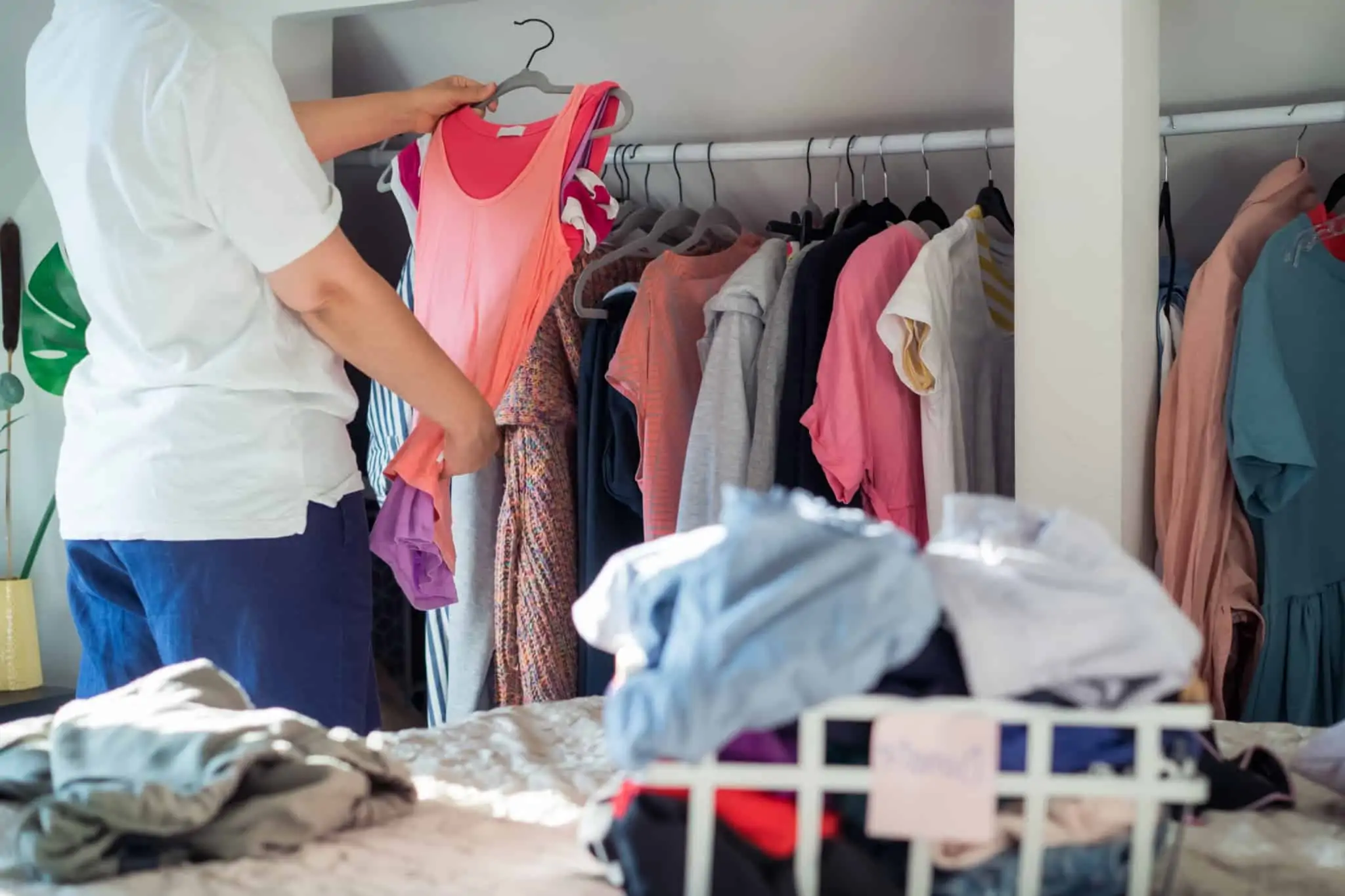 Jovem mulher a arrumar a roupa após ter descoberto 9 sites para comprar roupa barata