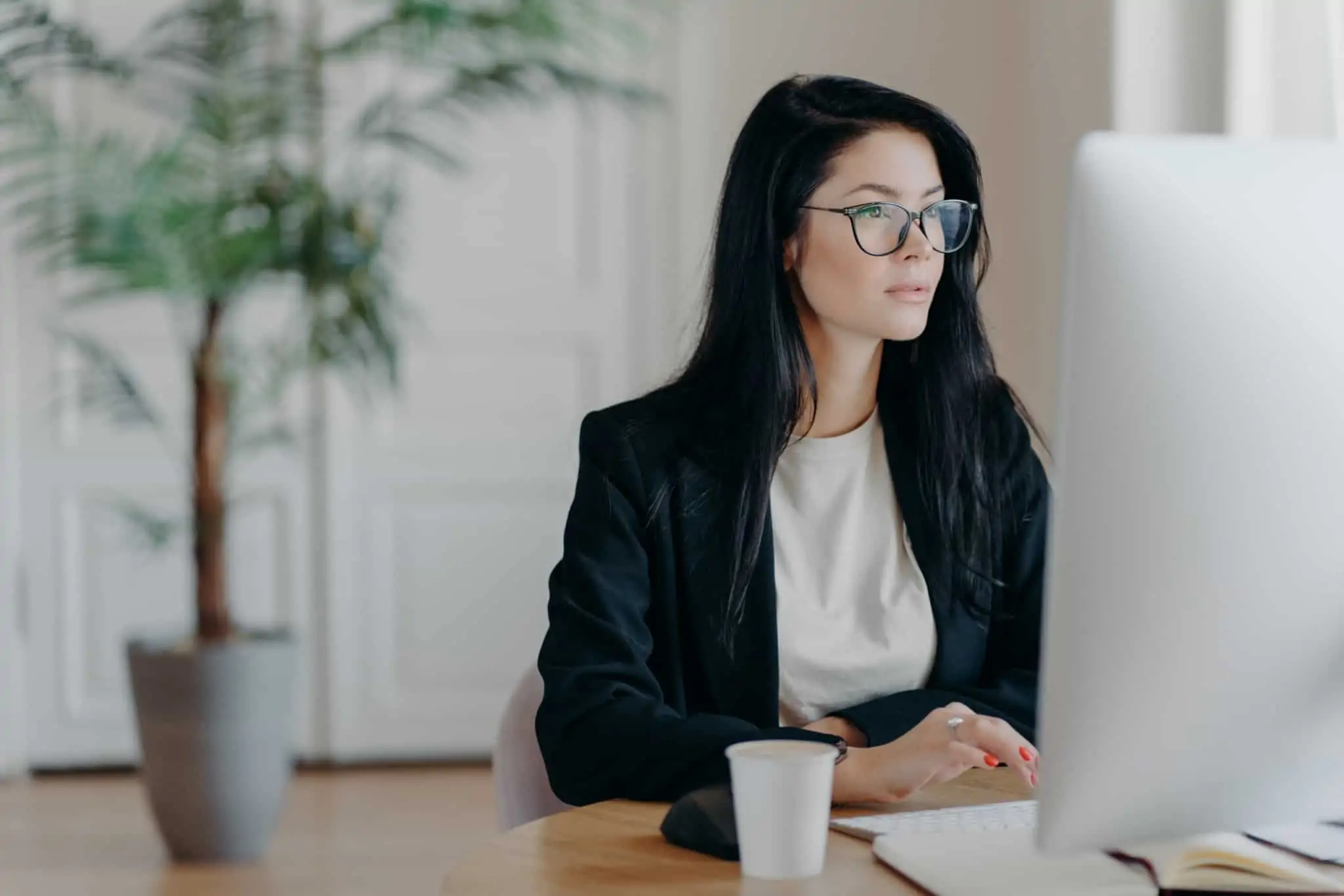 Certificado de Residência Fiscal em Portugal: Como obter jovem mulher trabalha ao computador e usa óculos