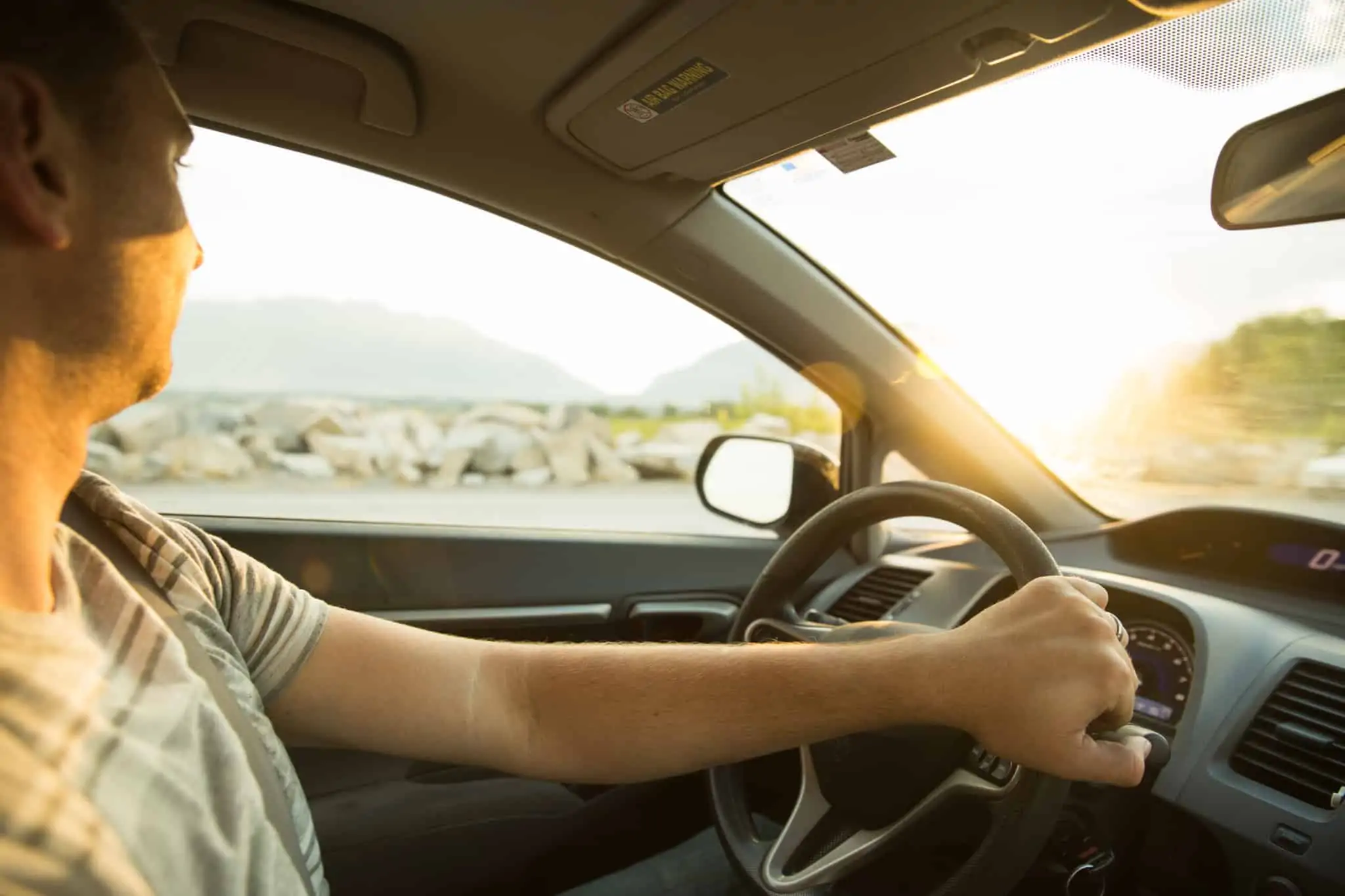 Multas de trânsito: Cumpra os prazos para pagar mas saiba como recorrer jovem homem ao volante do seu automóvel, num dia ensolarado.