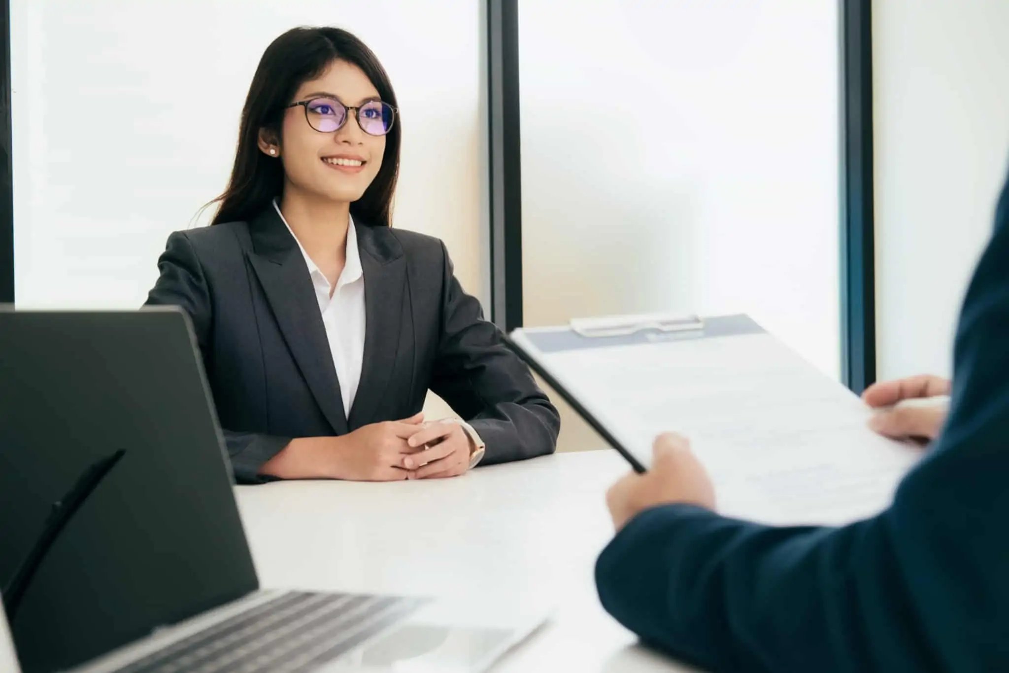 Qualidades a mencionar numa entrevista de emprego jovem mulher, recem licenciada, sorridente, confiante e com apresentação cuidada, na sua primeira entrevista de emprego