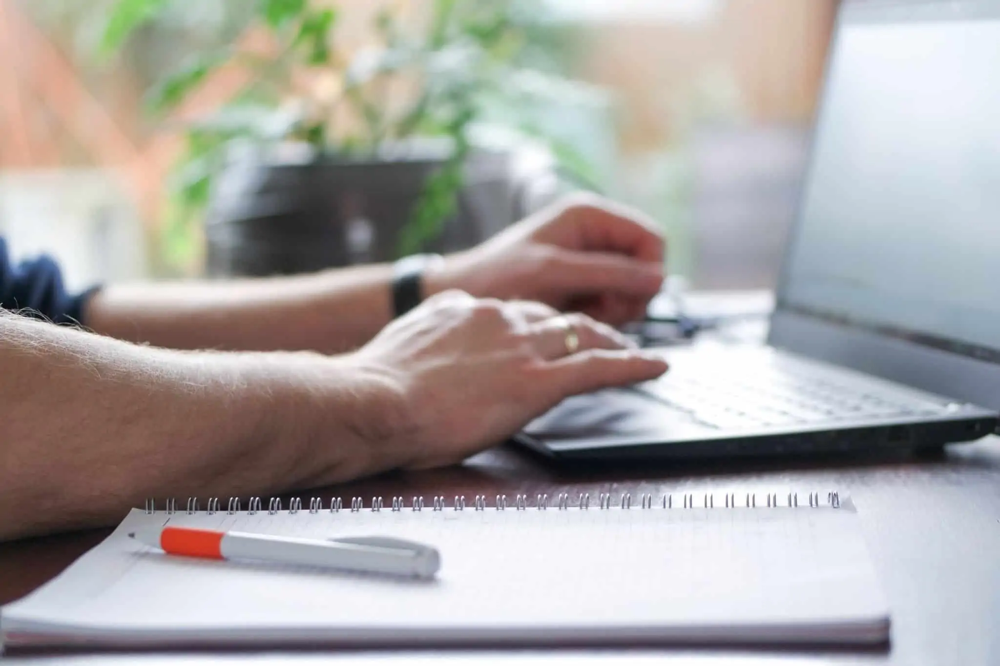 O que é a declaração de remunerações à Segurança Social? Homem ao computador com um caerno com as componentes de salário