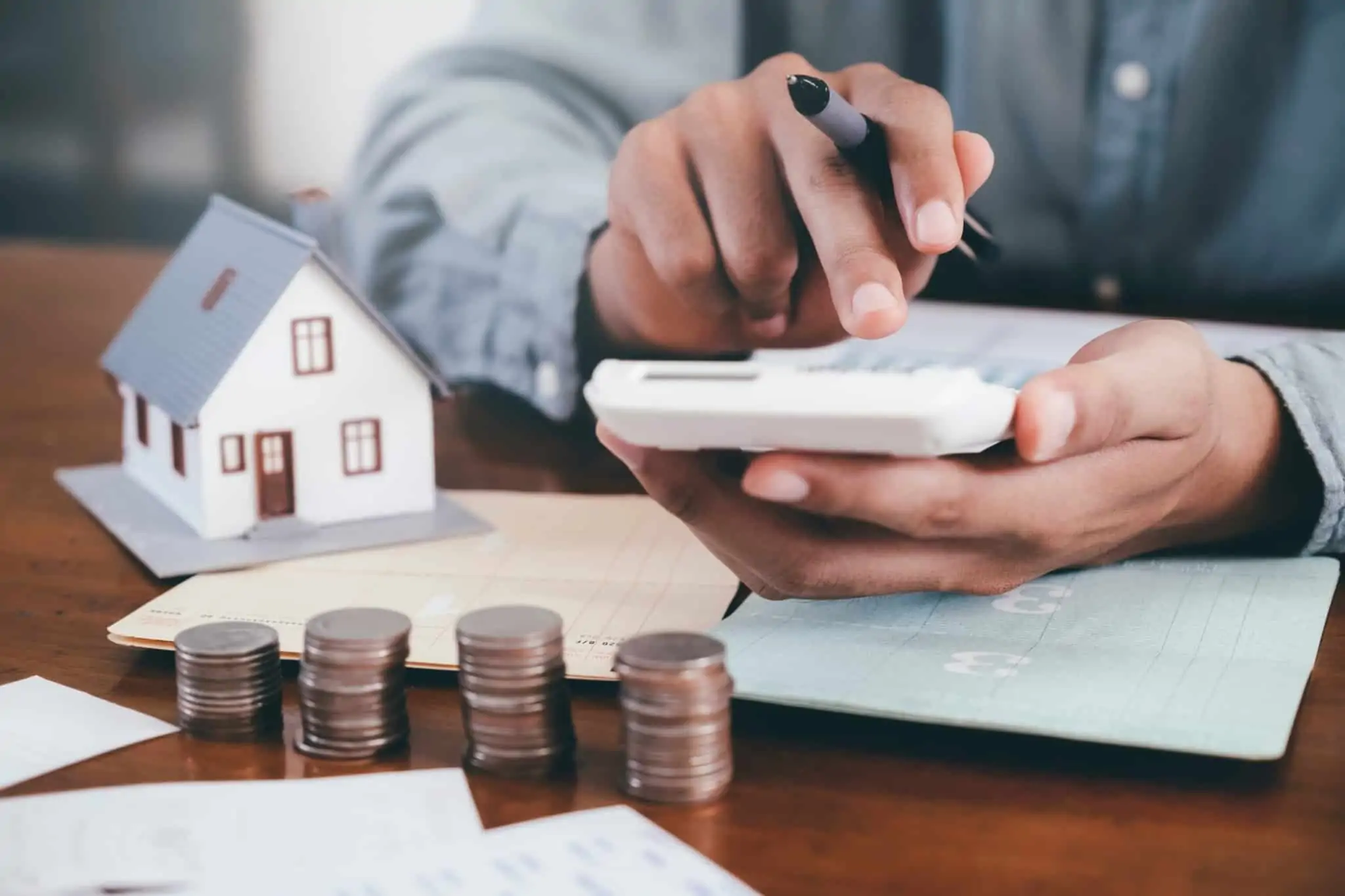 Comprar casa aos 30: Será que tem as condições para dar este passo? Jovem com 30 anos faz contas numa calculadora com os custos de comprar casa