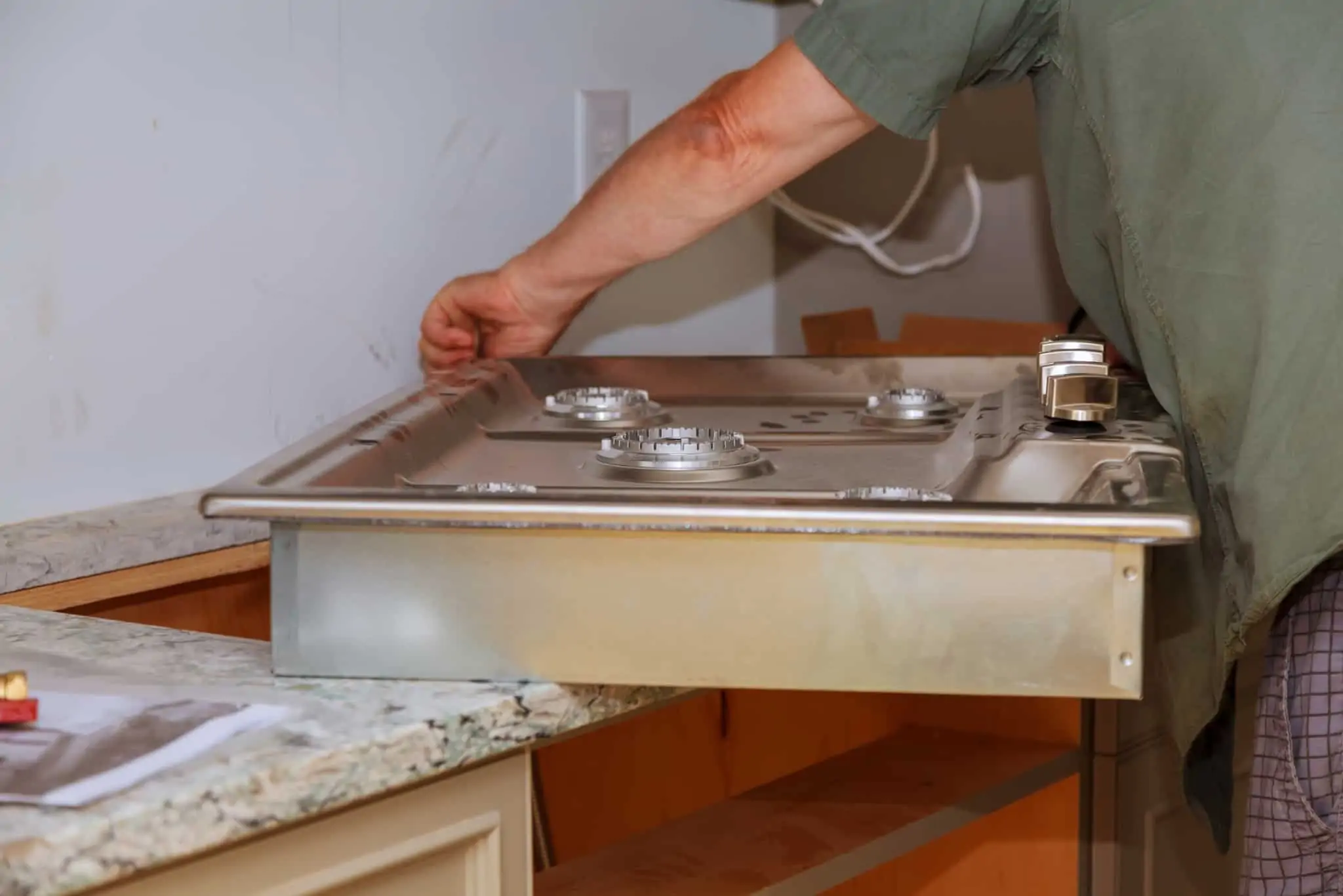 Inspeção de gás: Sabe quando deve ser feita e que procedimentos seguir? homem trata da inspeção de gás e colocação do fogão na respetiva bancada da cozinha