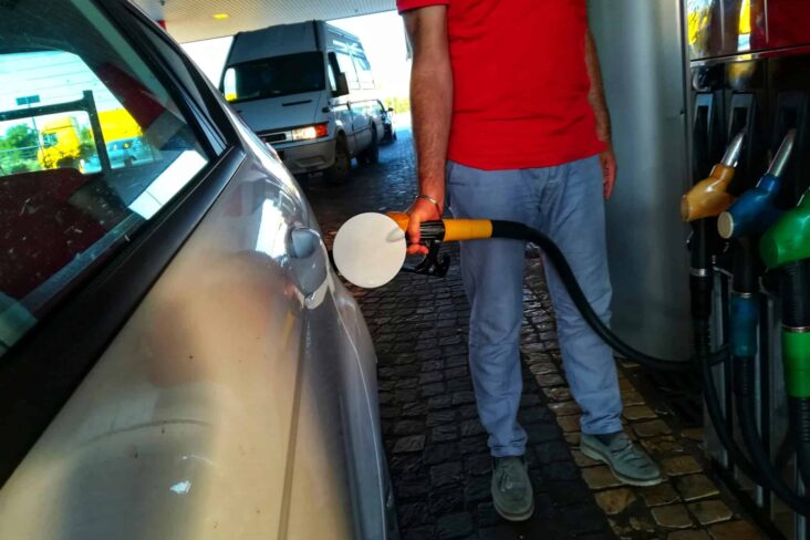 homem, na bomba de gasolina, abastece o seu automóvel