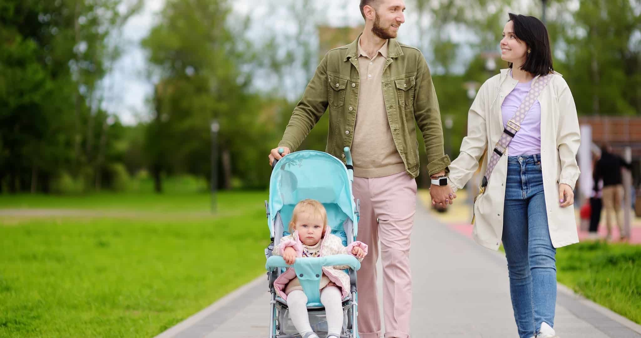 Abono: Escalões de referência do agregado familiar Dois pais a caminhar na rua com uma criança num carrinho que adotaram