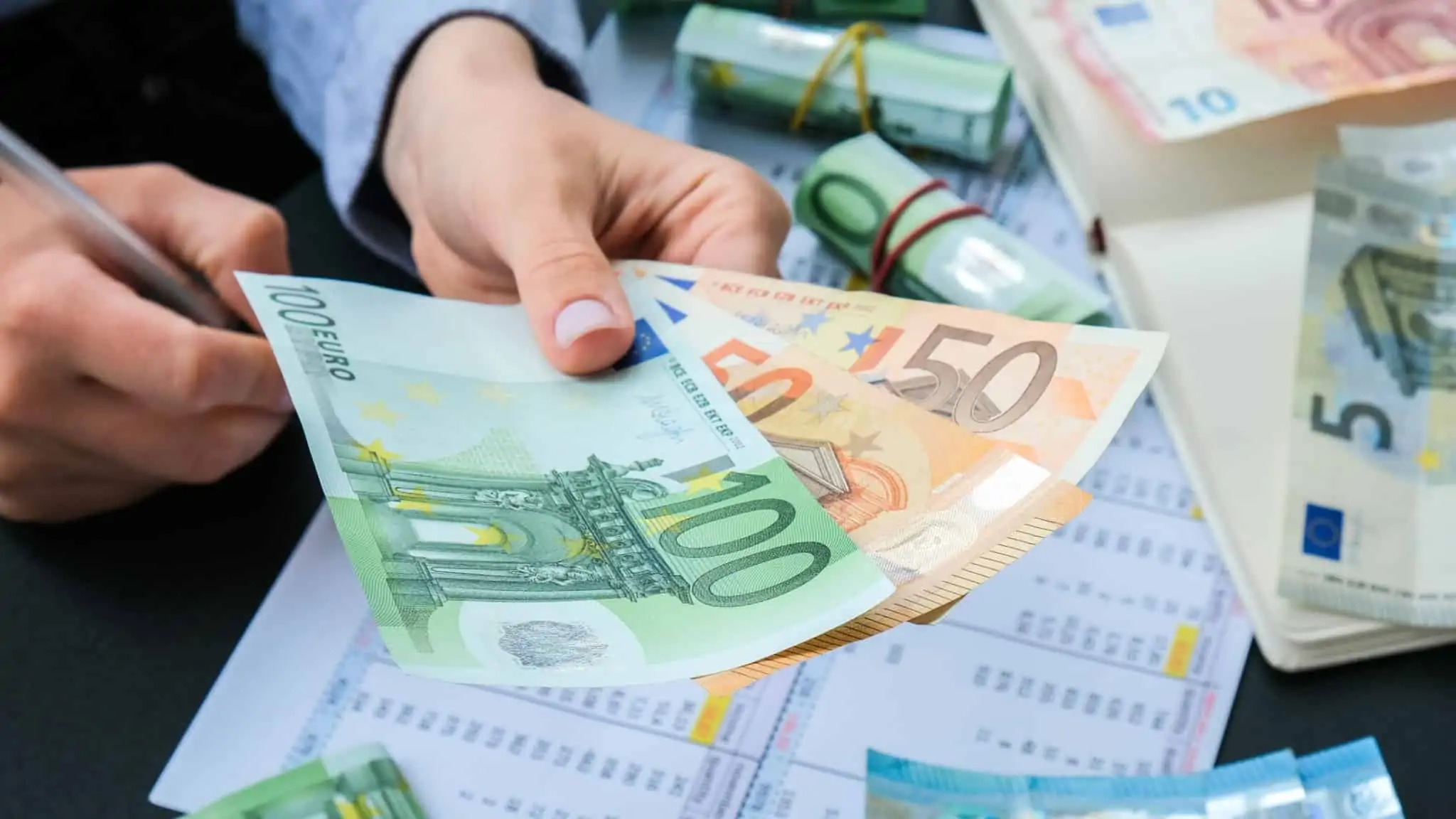 Imagem de uma mão a segurar notas de 100 e 50 euros - pagar crédito mais cedo
