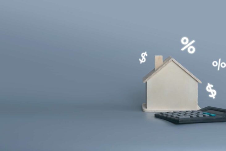 produção fotográfica mostra apenas uma casa rodeada por vários símbolos financeiros e acompanhada de uma calculadora a ilustrar as deduções de arrendamento que entram no IRS