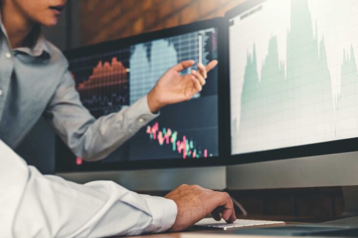 analistas consultam gráficos, em ecrans, para acompanhar a evolução das cotações