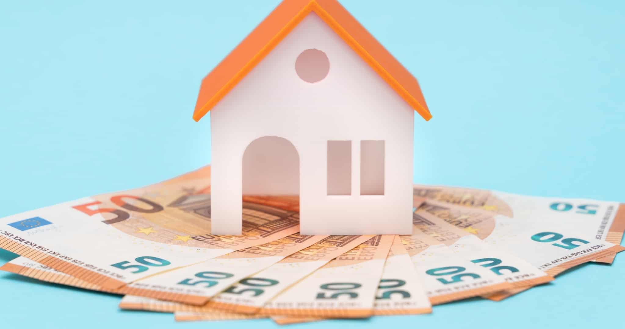 Casa de madeira com base de notas de 50 euros a simbolizar seguro de vida