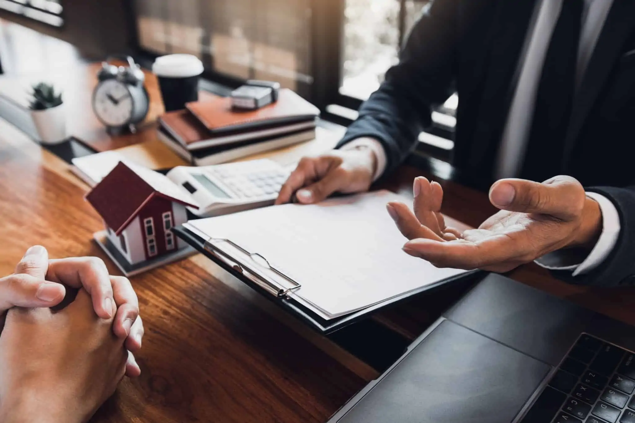 Fiador e avalista: Quais as diferenças? dois homens, numa mesa de escritório, analisam papel para assinar