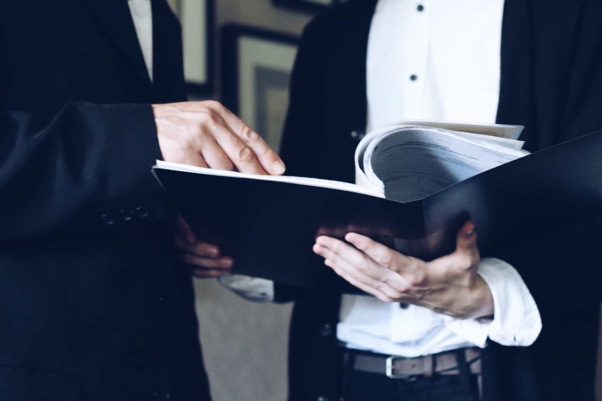 dois homens consultam documento com informações