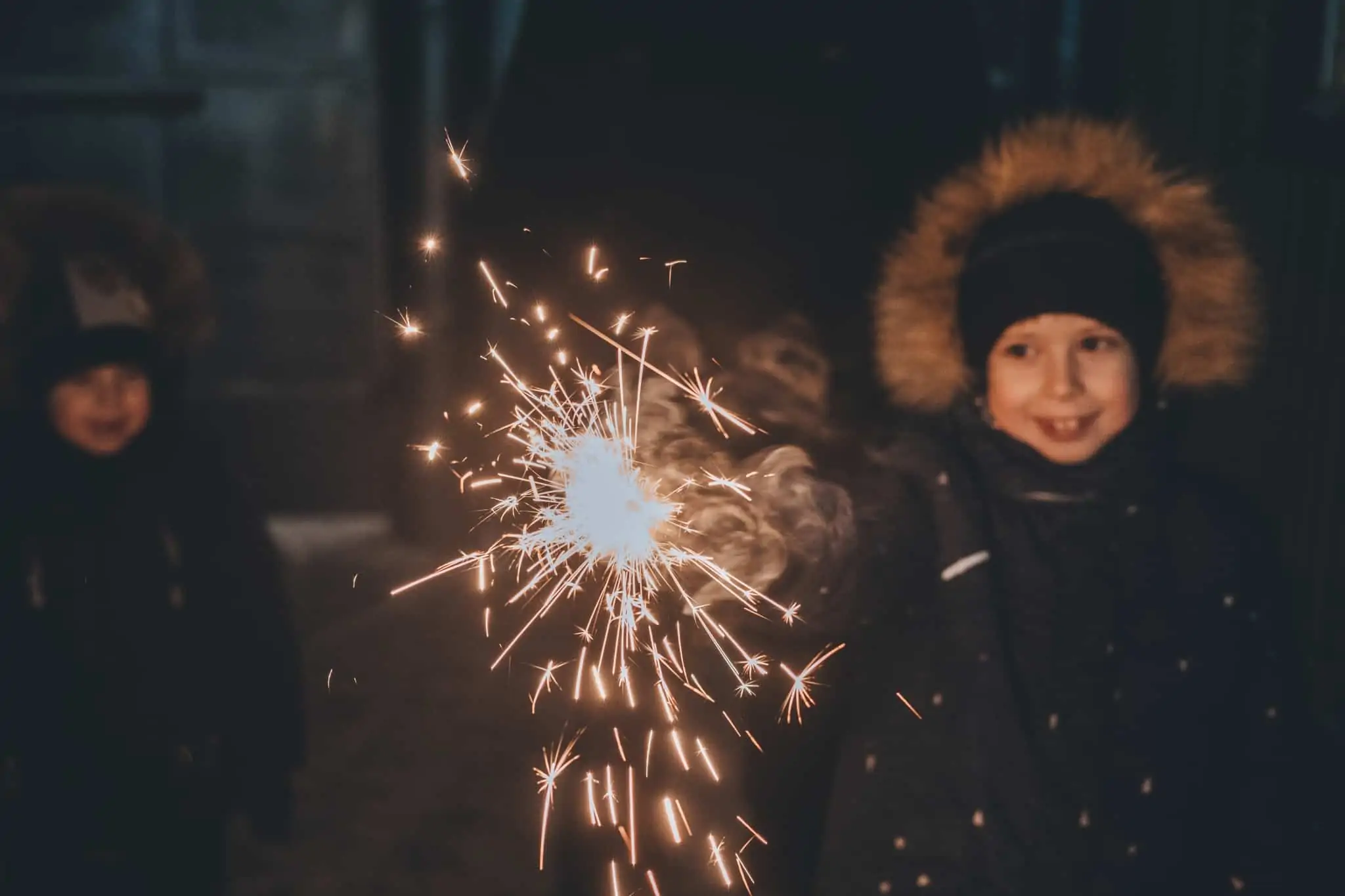 Passagem de ano: 7 atividades para entreter as crianças na festa crianças celebram a passagem de ano na rua, protegidos do frio, com muita alegria e com velas com faíscas