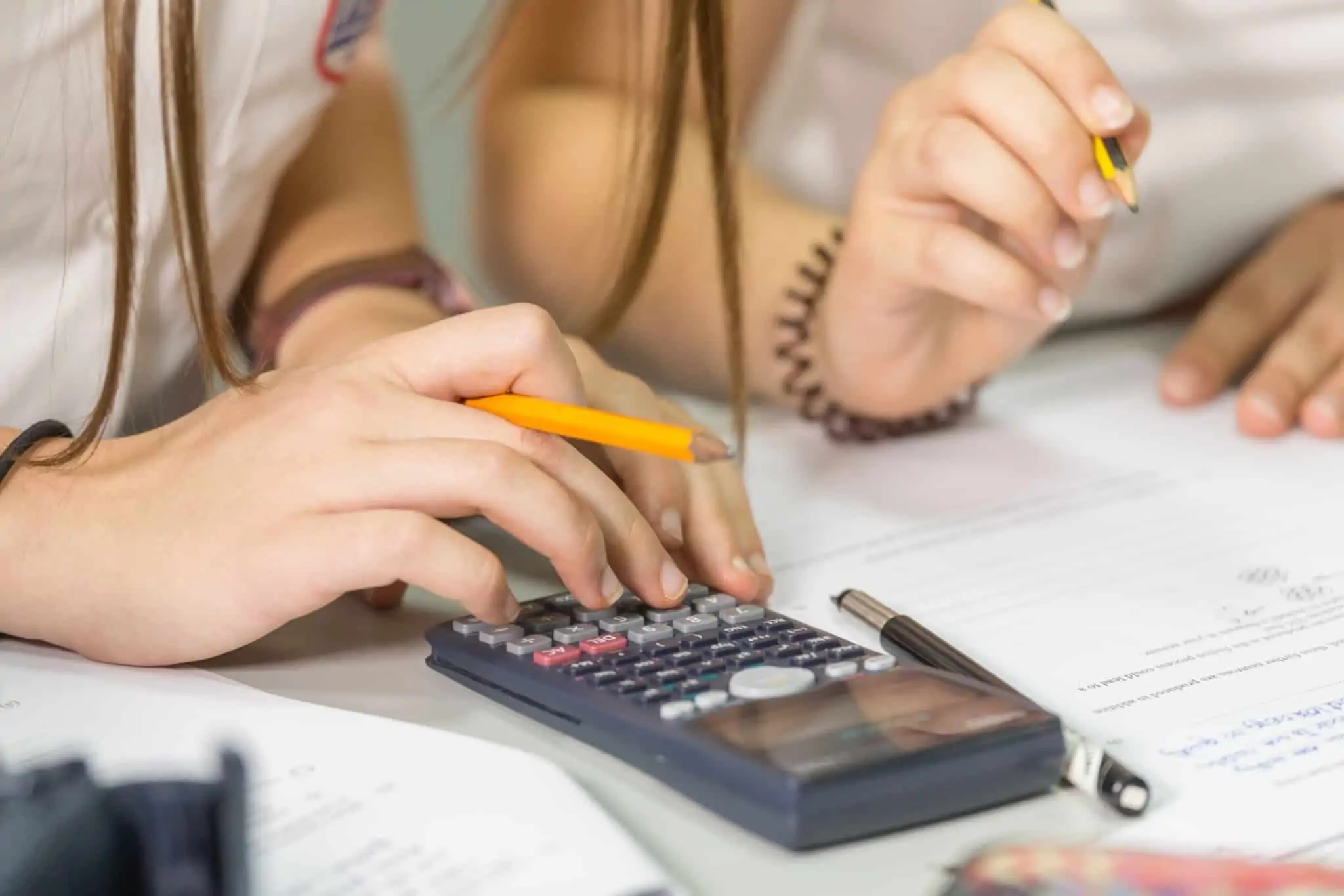 Taxa Social Única: Como funciona Imagem de duas pessoas a fazer contas numa calculadora - rever seguros
