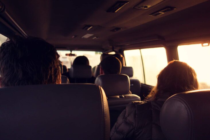 grupo de jovens partilha uma viagem, numa carrinha, rumo ao emprego