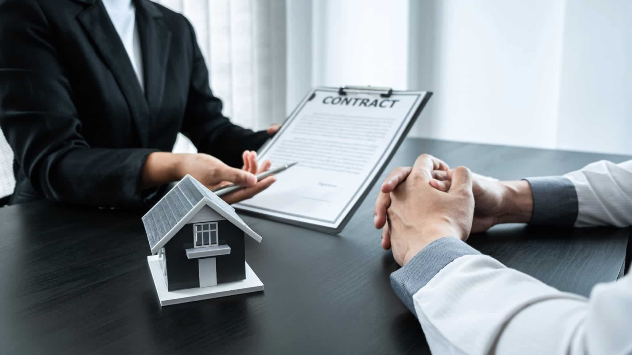 duas pessoas com um contrato no meio e uma casa em destaque