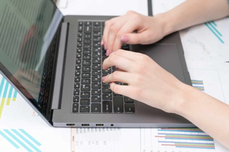 mãos de uma mulher a escrever no portátil, a atualizar os dados na Segurança Social Direta