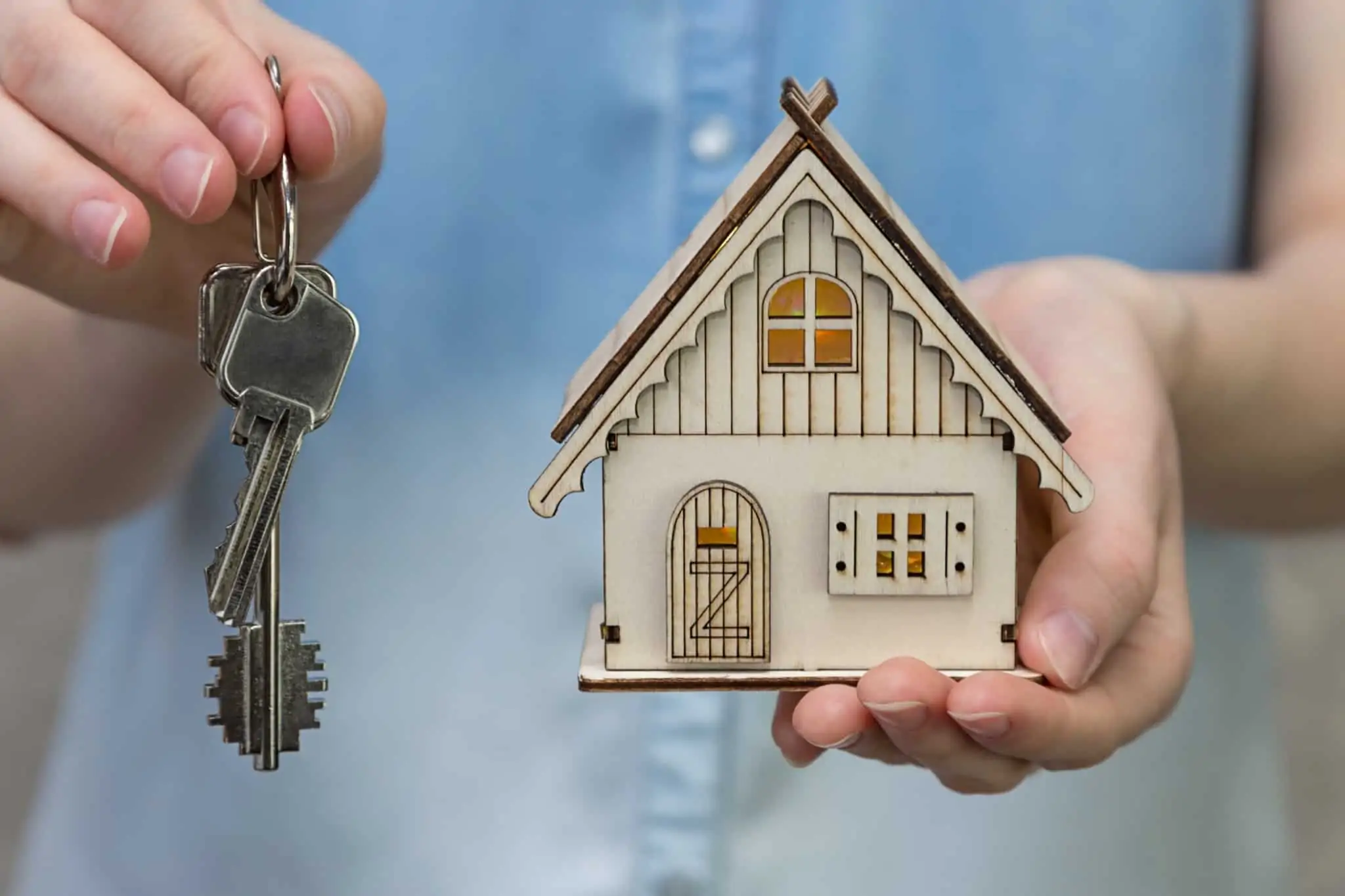Qual o momento certo para comprar casa? mão a segurar uma casa e outra mão a segurar umas chaves