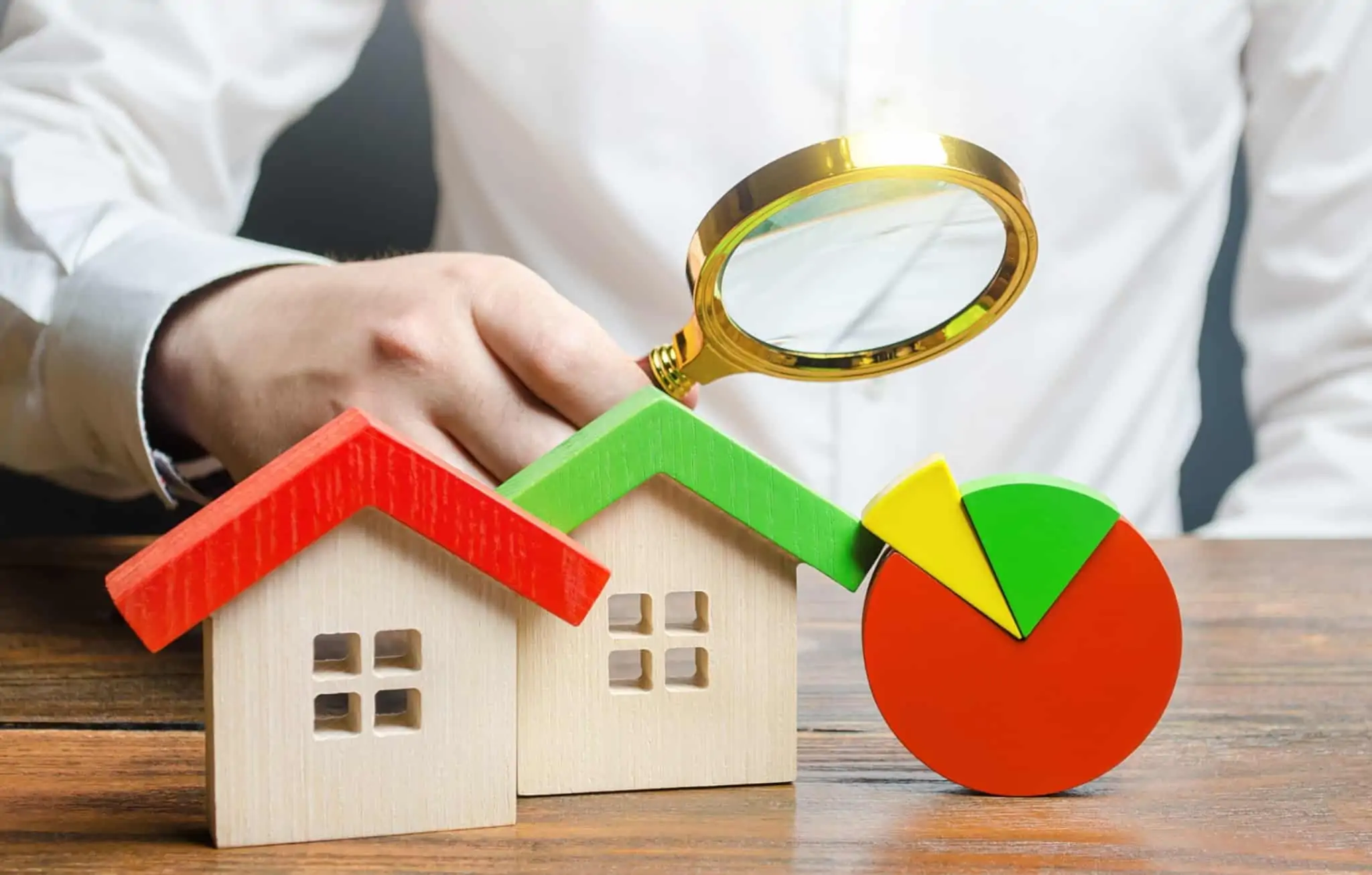 Recibos de renda e despesas com habitação: Como consultar e validar duas casas, um gráfico e um homem a segurar uma lupa