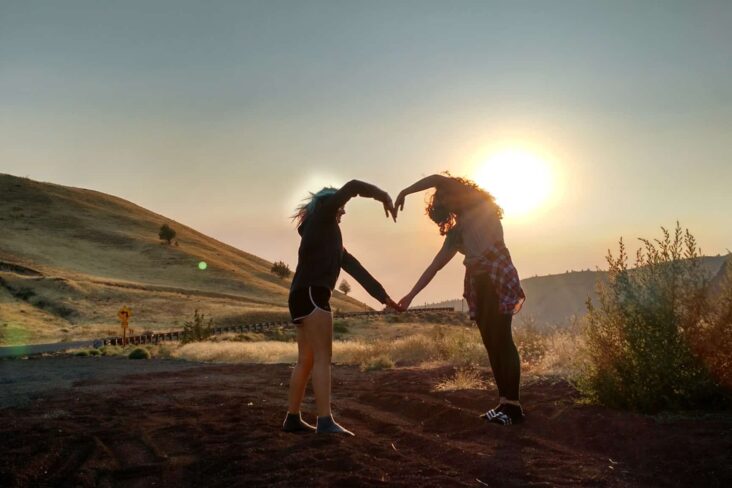 Casal desenha com os braços um coração, numa alusão ao dia dos namorados