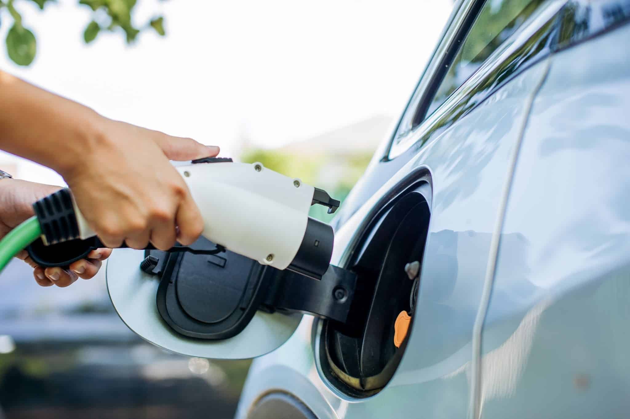 Mão carrega carro elétrico