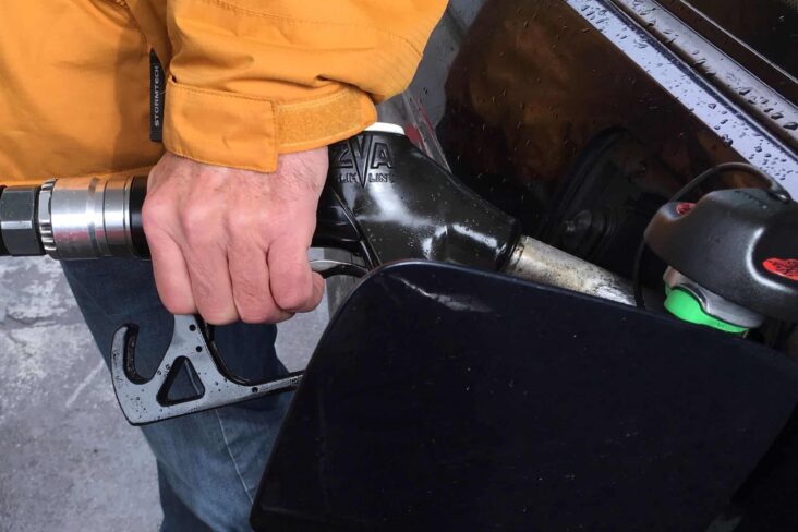 Homem agarra na mangueira para abstecer o carro, tentando poupar combustível