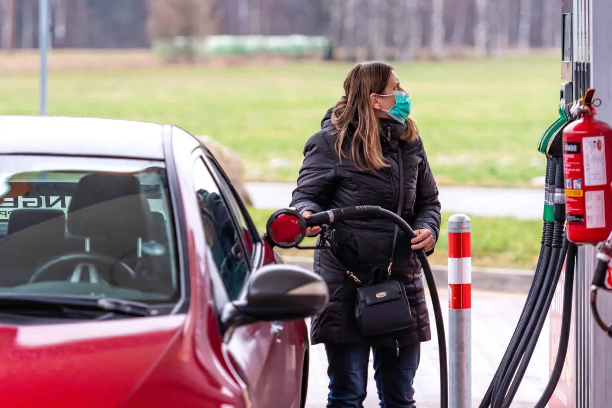 AUTOvoucher: Benefício de 20 euros mantém-se em abril jvem mulher a abastecer o seu carro numa bomba de gasolina (está a usar a máscara de proteção Covid-19)