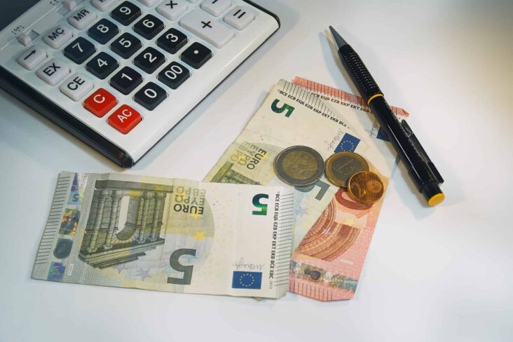 calculadora, notas e moedas de euro
