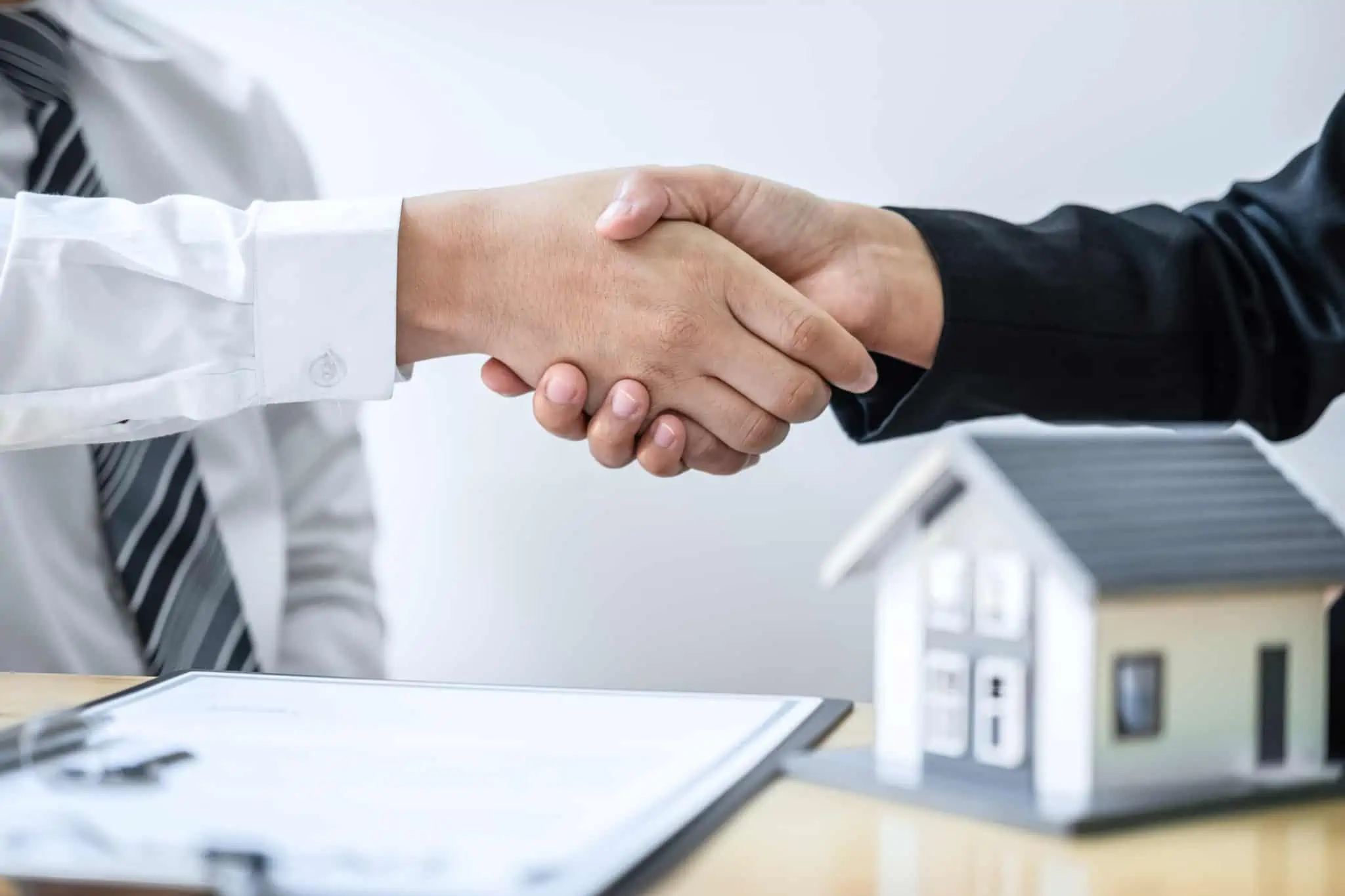 Quantos bancos devo consultar antes de avançar com um crédito? dias pessoas a apertarem a mão com uma proposta na mesa
