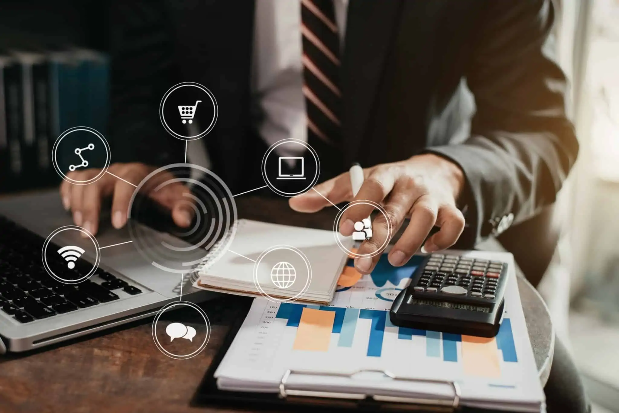 homem, no escritório, faz contas com apoio de calculadora e consultando documentos para fazer transferência via homebanking