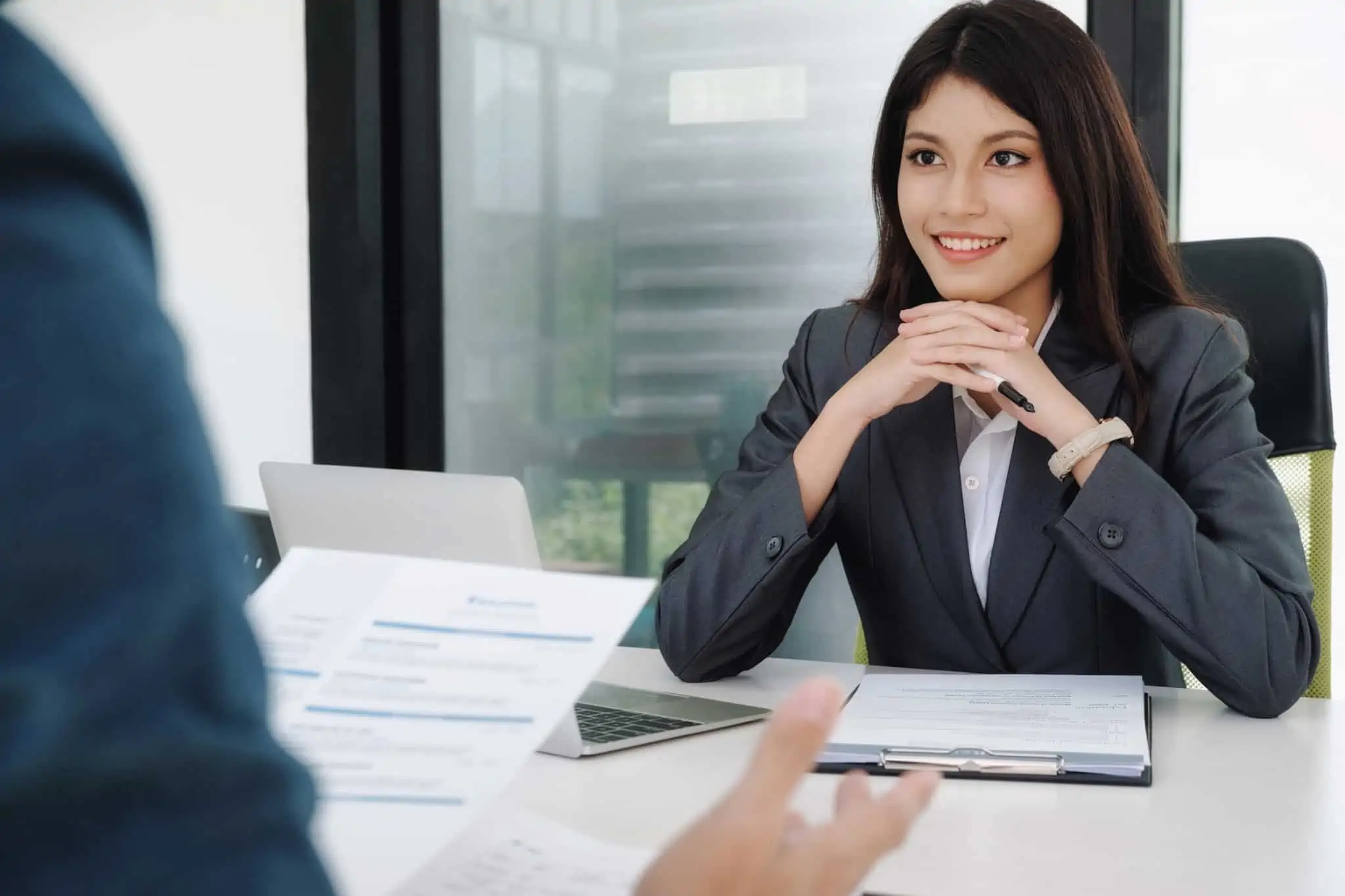 10 exemplos de soft skills importantes para o futuro mulher sentada numa entrevista de trabalho antes de aceitar o primeiro emprego