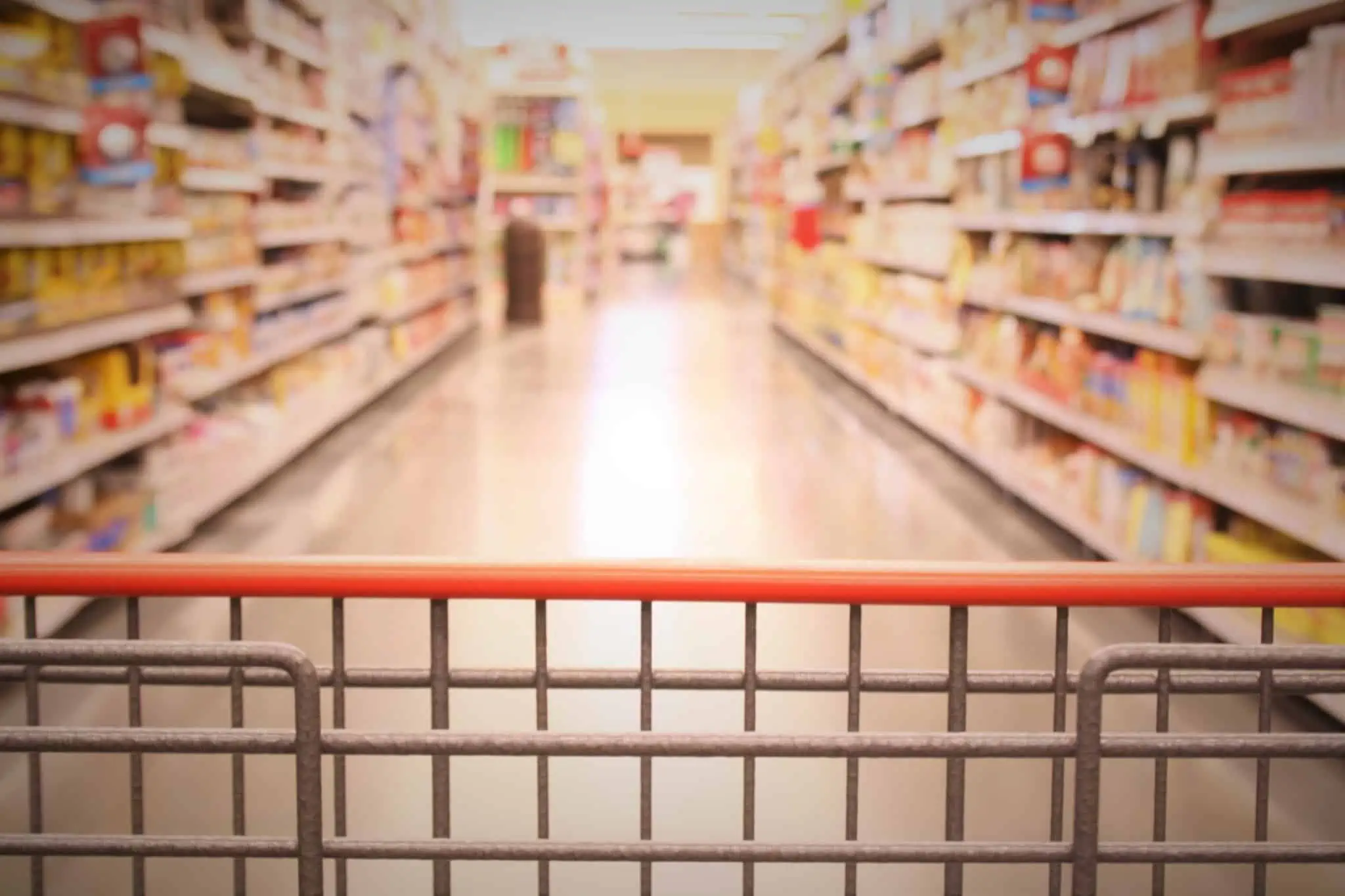 Carrinho de supermercado a percorrer corredores enquanto família faz compras