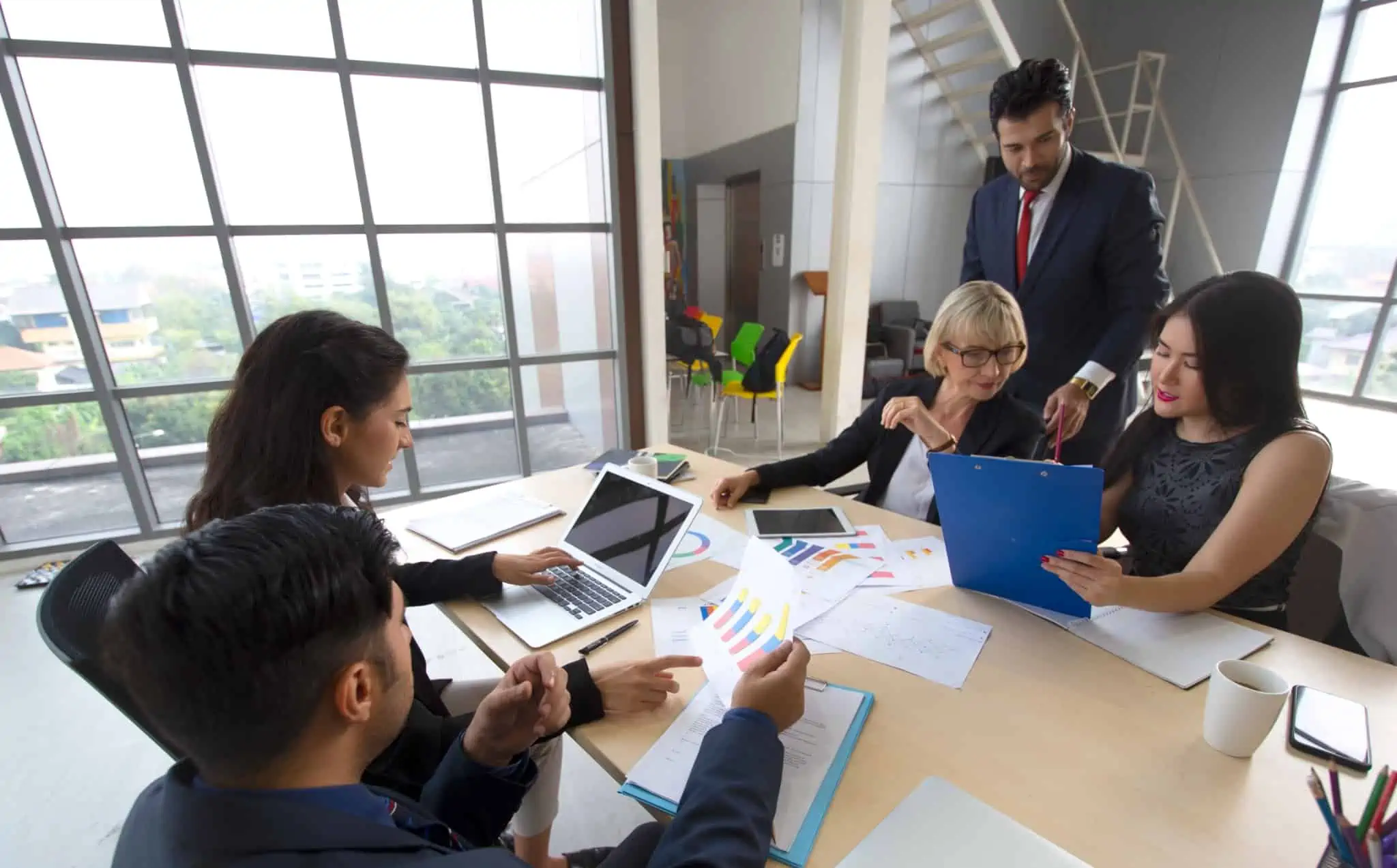 IES – Informação Empresarial Simplificada: O que é esta declaração? cinco pessoas a trabalhar com gráficos e no computador para preencher a IES - Informação Empresarial Simplificada