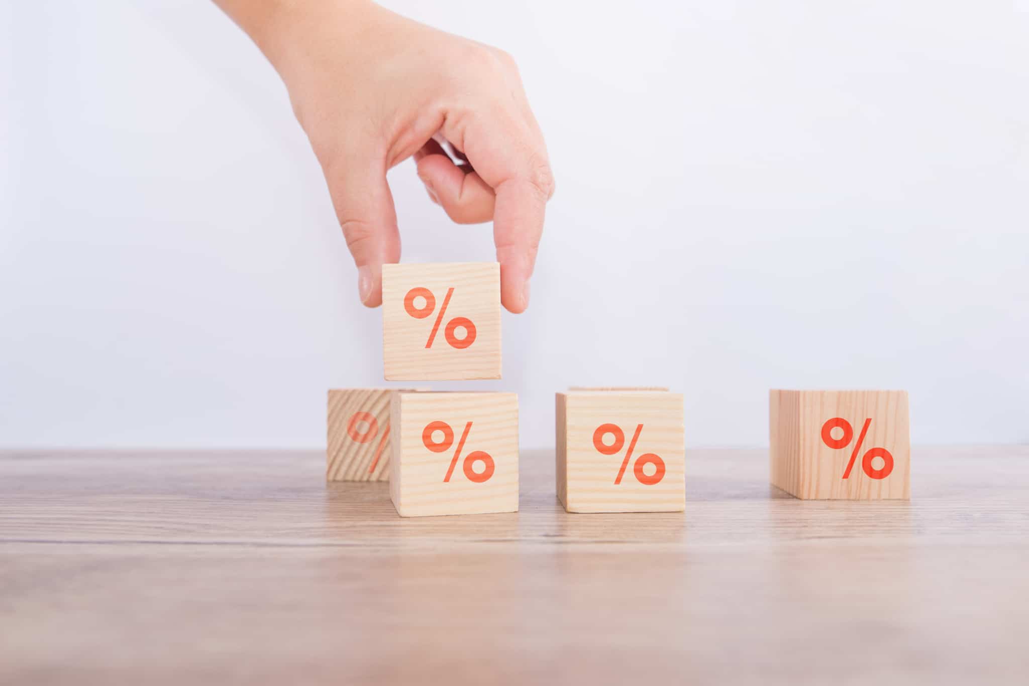 Blocos de madeira com símbolos de percentagem, numa alusão às taxas de juro no crédito habitação