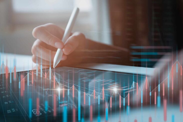 mão segura caneta que percorre tablet que, em 3D, projeta cruzamento de informações de uma análise fundamental em investimento em ações