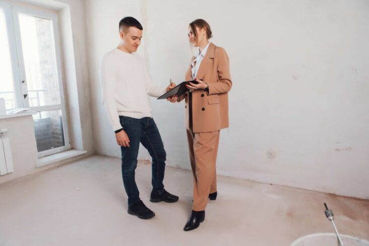 jovem rapaz, na companhia de uma agente imobiliária, acaba de encontrar casa e assina documento para agarrar oportunidade