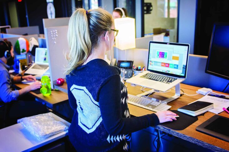 jovem mulher no escritóio, a trabalhar no computador, no seu primeiro trabalho