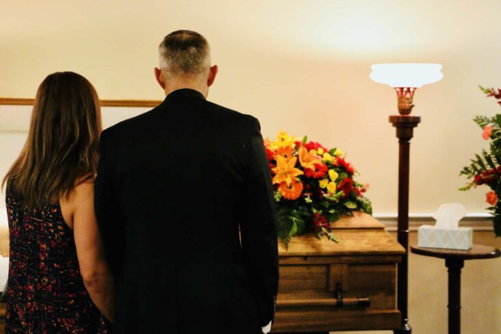 casal em ambiente de um funeral , cerimónia que pode ser apoiada financeira, entre outras prestações por morte