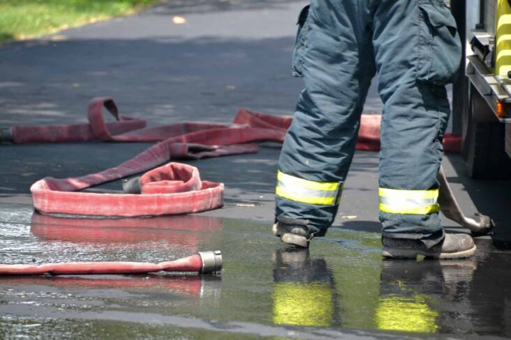 foro mostra apenas as pernas de um bombeiro voluntário, após intervenção com as mangueiras e com os pés na água, sendo esta uma das atividades abrangidas pelo seguro social voluntário