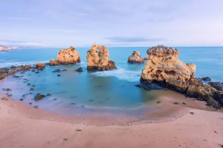 Pôr do Sol numa praia do Algarve, onde se vê o mar e alguma rochas