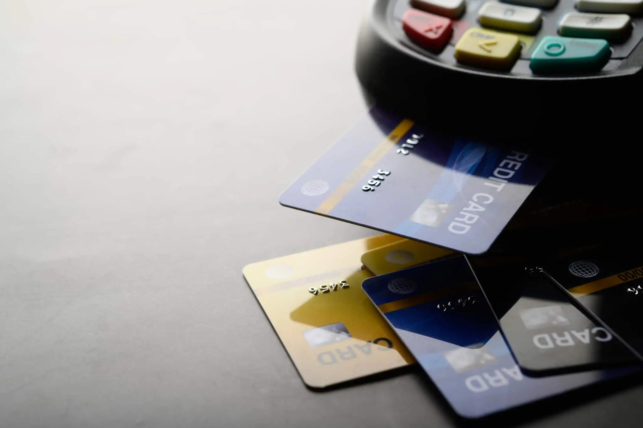 Qual é a diferença entre Visa e MasterCard? vários tipos cartões crédito sendo que está inserido num terminal de pagamento colocado me cima de uma mesa