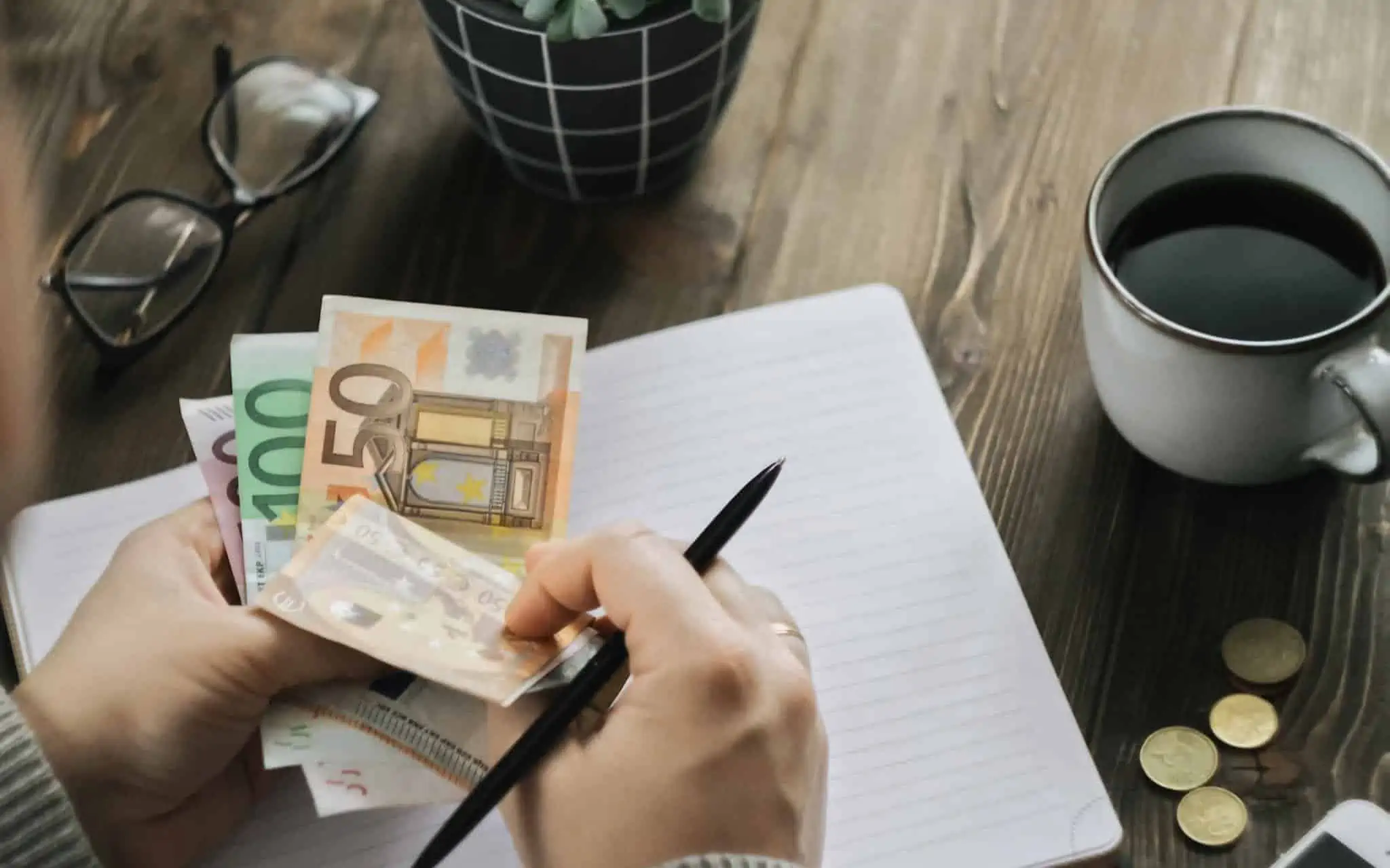 Quem tem direito a ajudas de custo? Homem com várias notas de euro na mão, conta o dinheiro
