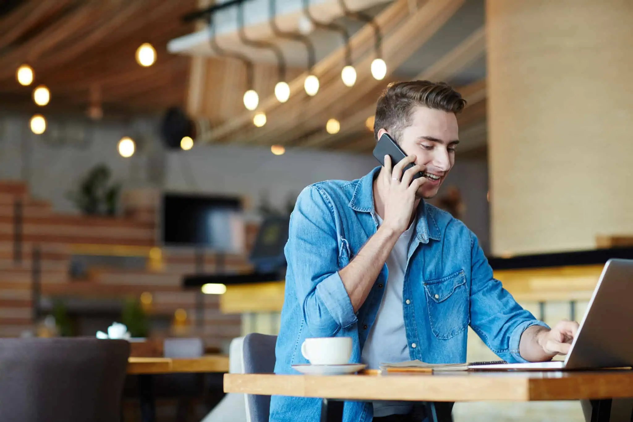 É freelancer? Saiba como iniciar atividade e escolher soluções financeiras jovem rapaz freelancer trabalha num café com um ar bem disposto e dinâmico
