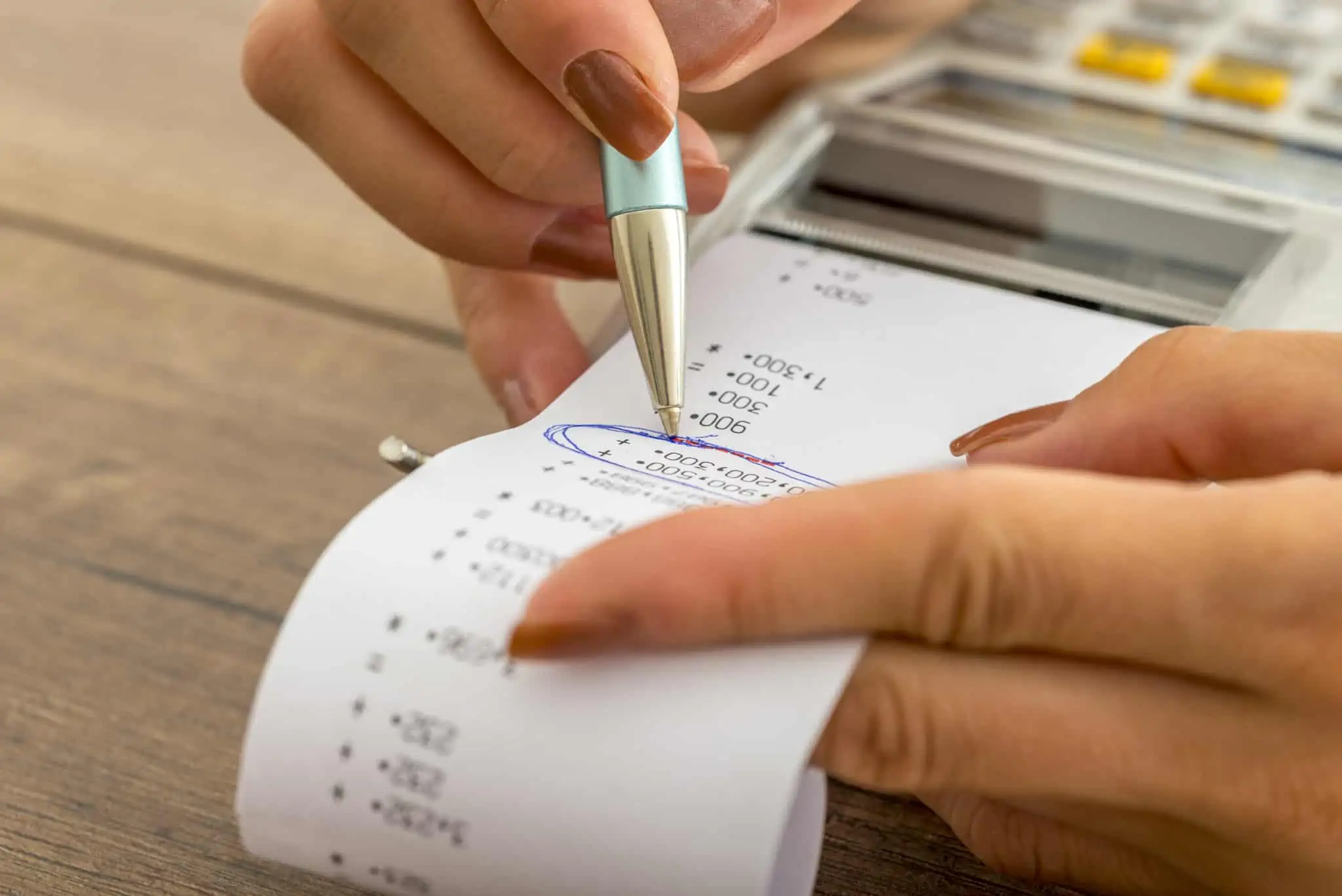 Escalões de IRS e retenções na fonte: Quais as diferenças? mulher a fazer contas numa calculadora