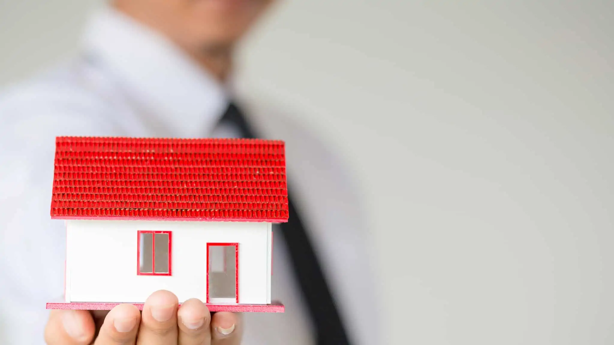 Comprar casa para arrendar, com crédito habitação maquete de casa na mão de um homem