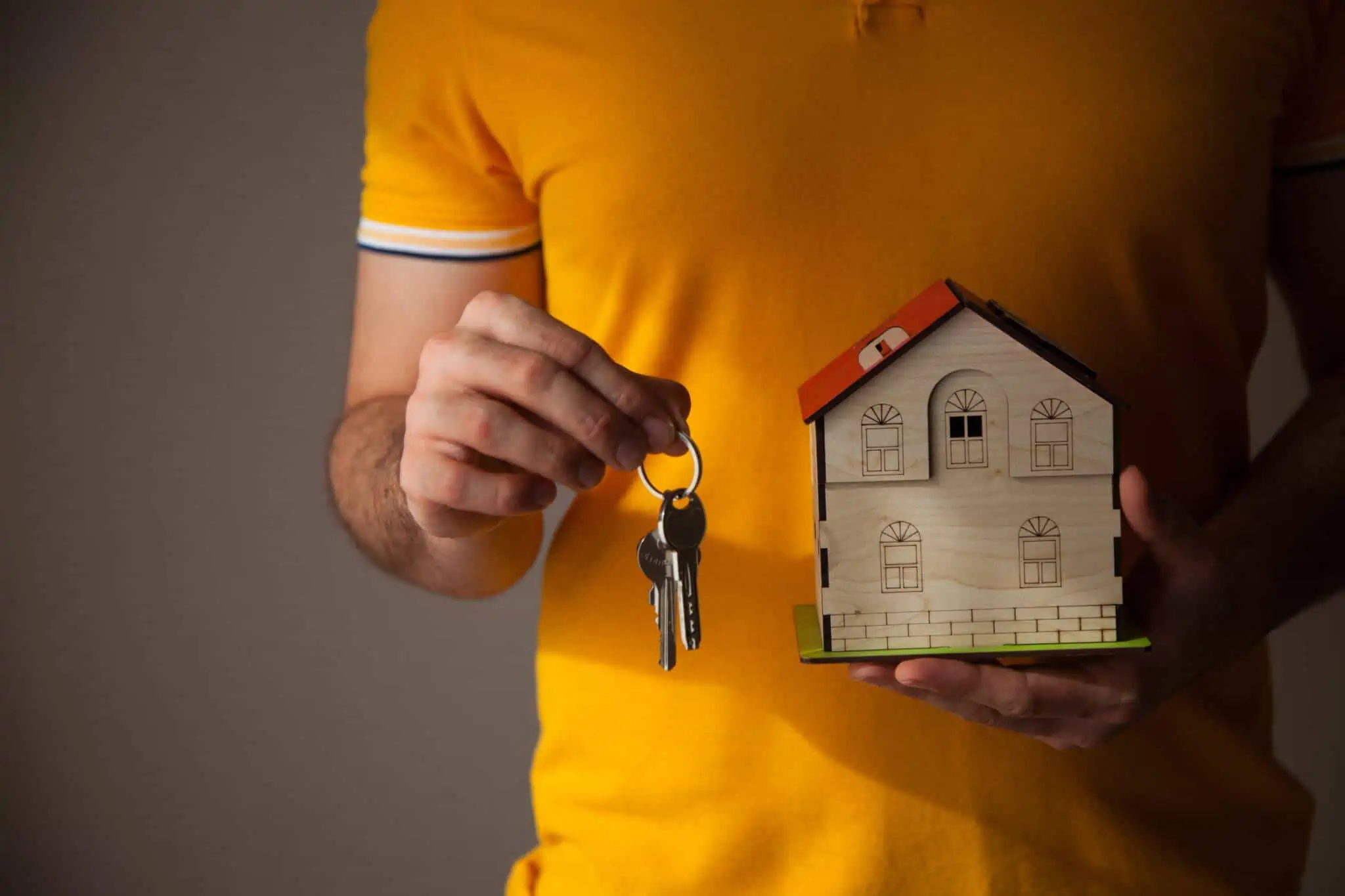 Que erros devo evitar cometer na compra da primeira casa? Pessoa com as chaves na mão após a compra da primeira casa