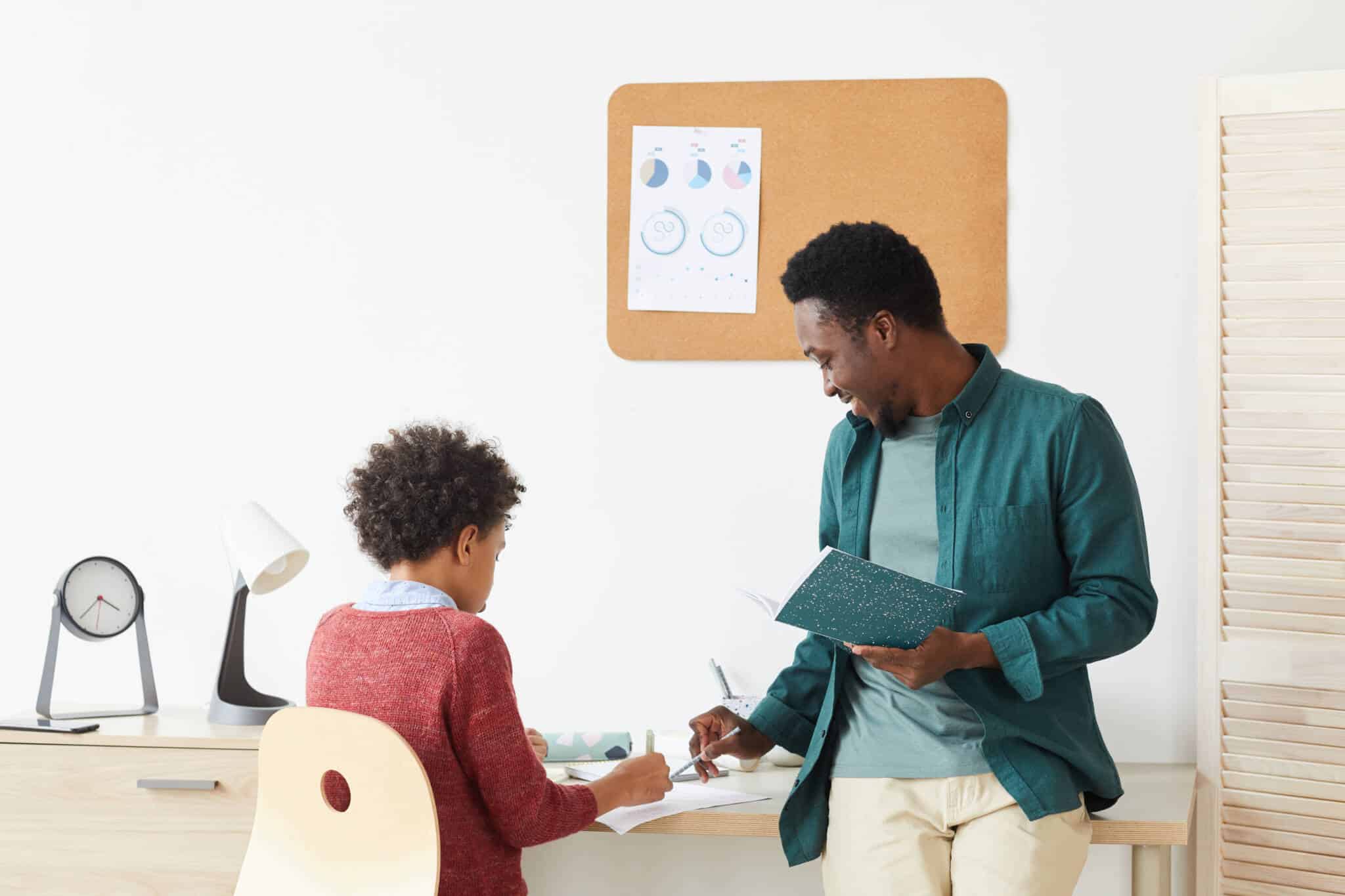 pai e filho pequeno, na secretária de estudo no quarto, reveem a matéria, seguindo algumas dicas para ajudar filho a ter melhores notas