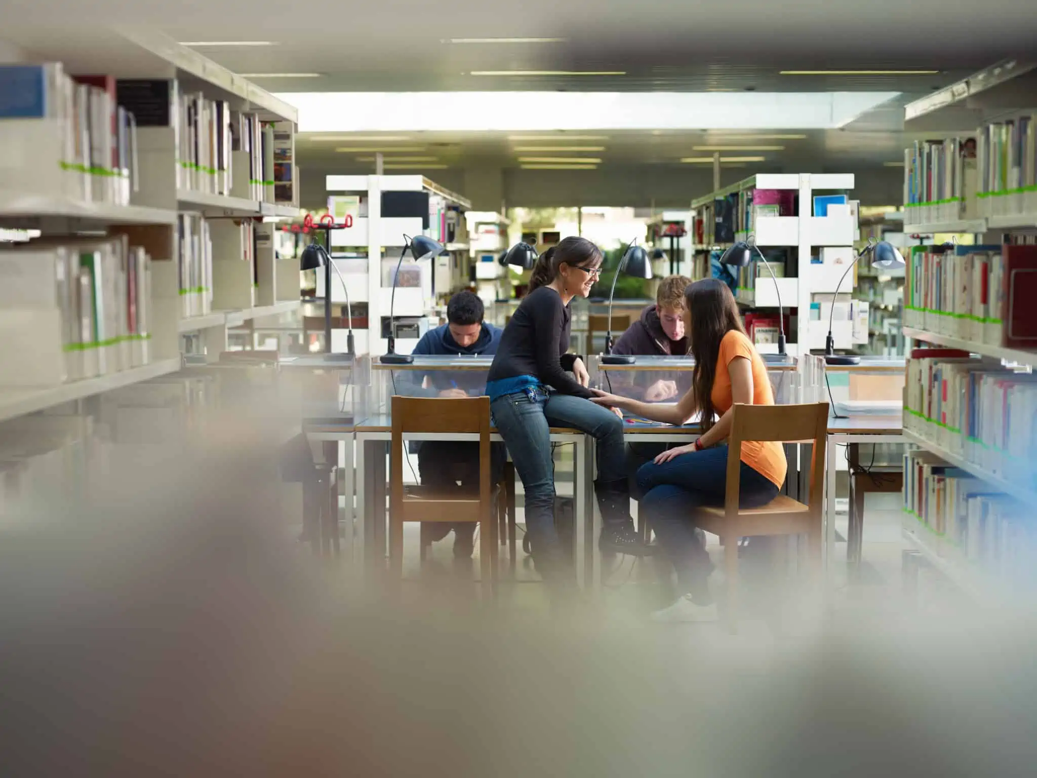 grupode jovens estudantes universitários, no ambiente de uma biblioteca, ilustram a decisão de estudar no interior de Portugal e os apoios que existem