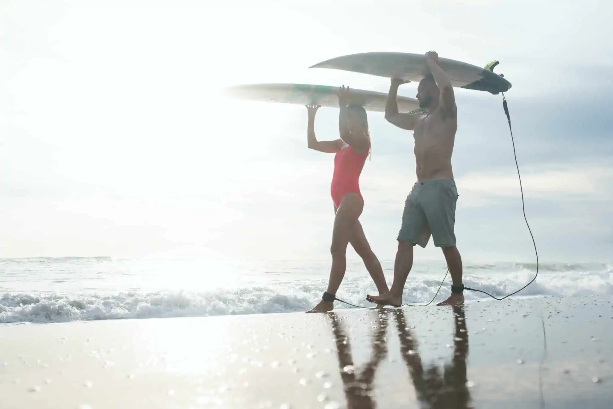 Regra dos 4%: Ainda faz sentido nos dias de hoje? Jovens na praia a carregar pranchas de surf