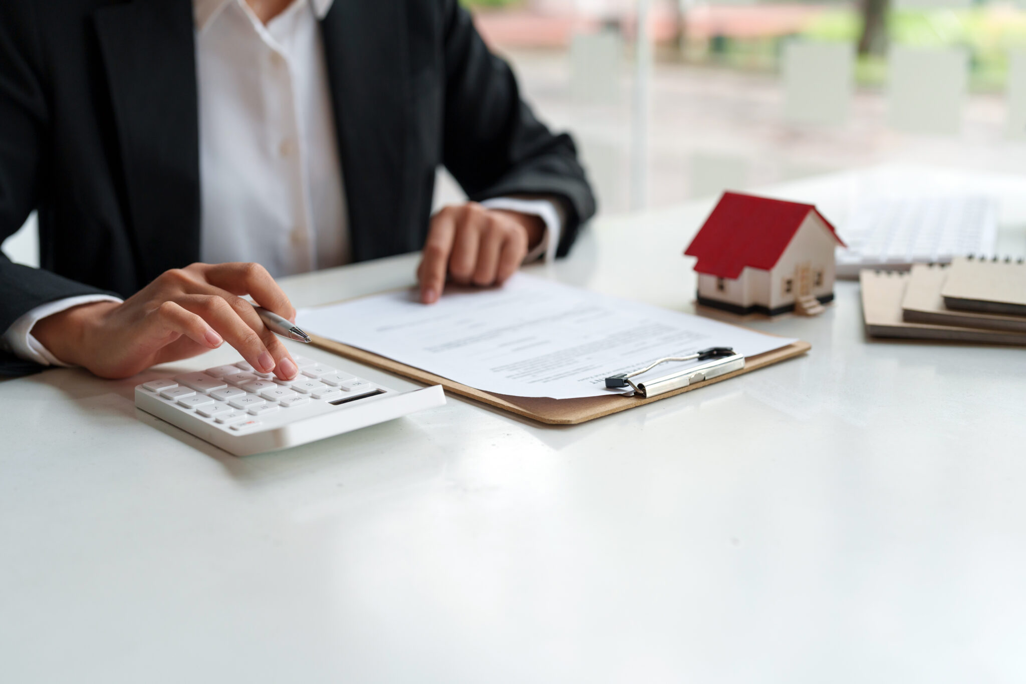 pessoa a fazer contas numa calculadora para perceber quanto é que o banco empresta para comprar casa